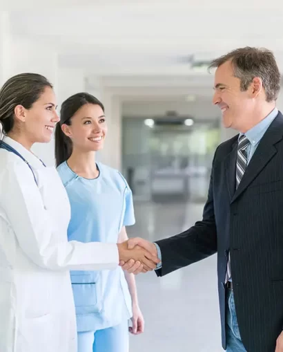 Doctor greeting health insurance agent with a handshake at the hospital