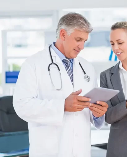 Confident doctor and pretty businesswoman discussing in medical office