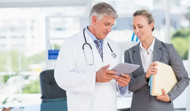 Confident doctor and pretty businesswoman discussing in medical office