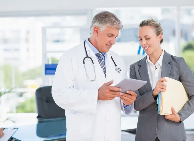 Confident doctor and pretty businesswoman discussing in medical office